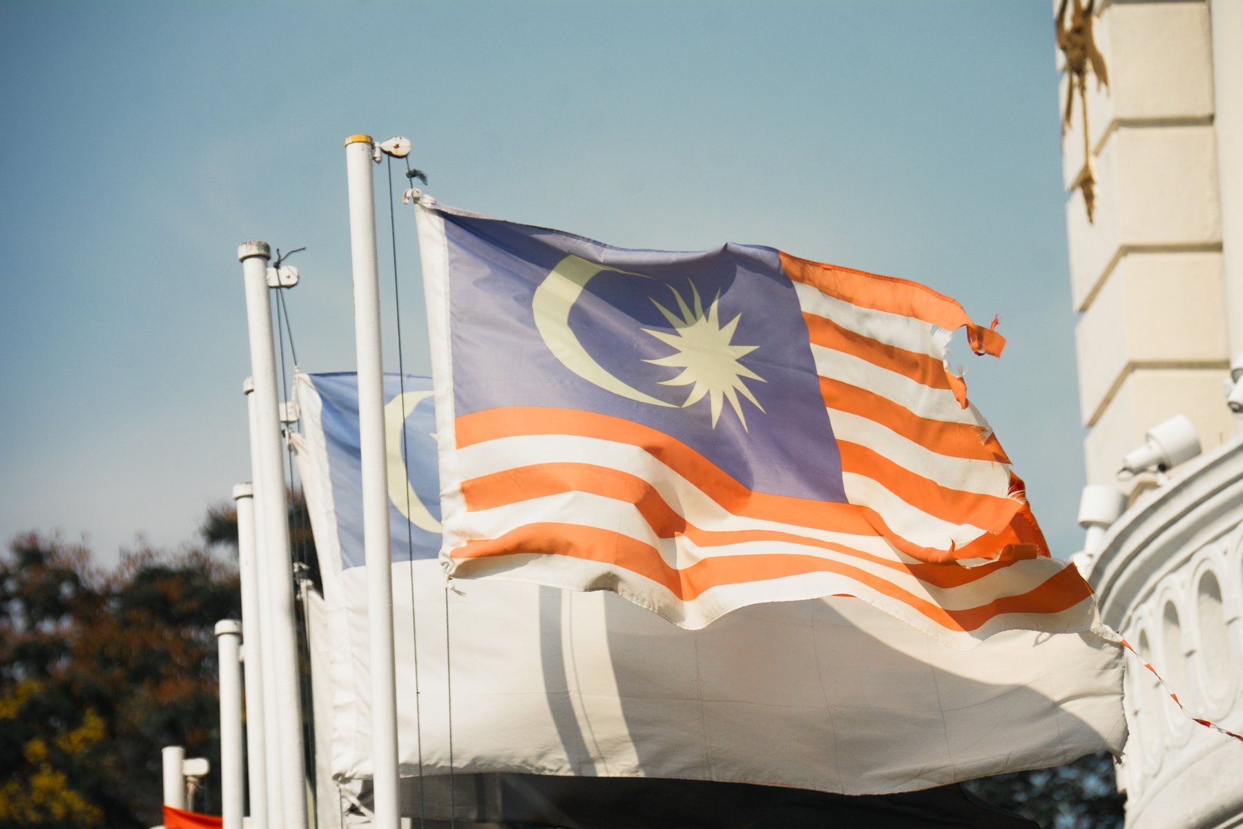 The Malaysian flag flying beside a colonial-era building