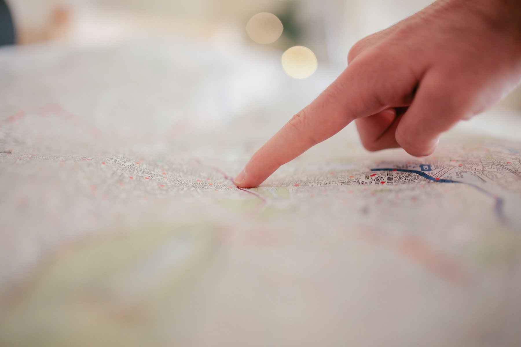 A fingertip tracing a route on a printed map, close up