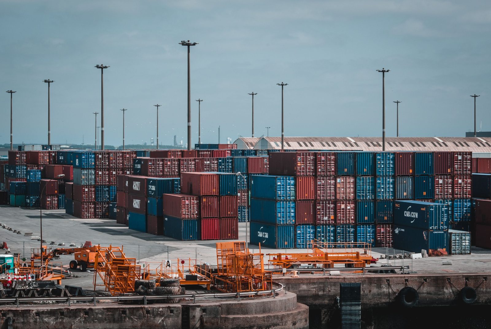 Stacked shipping containers in a port yard behind the quay