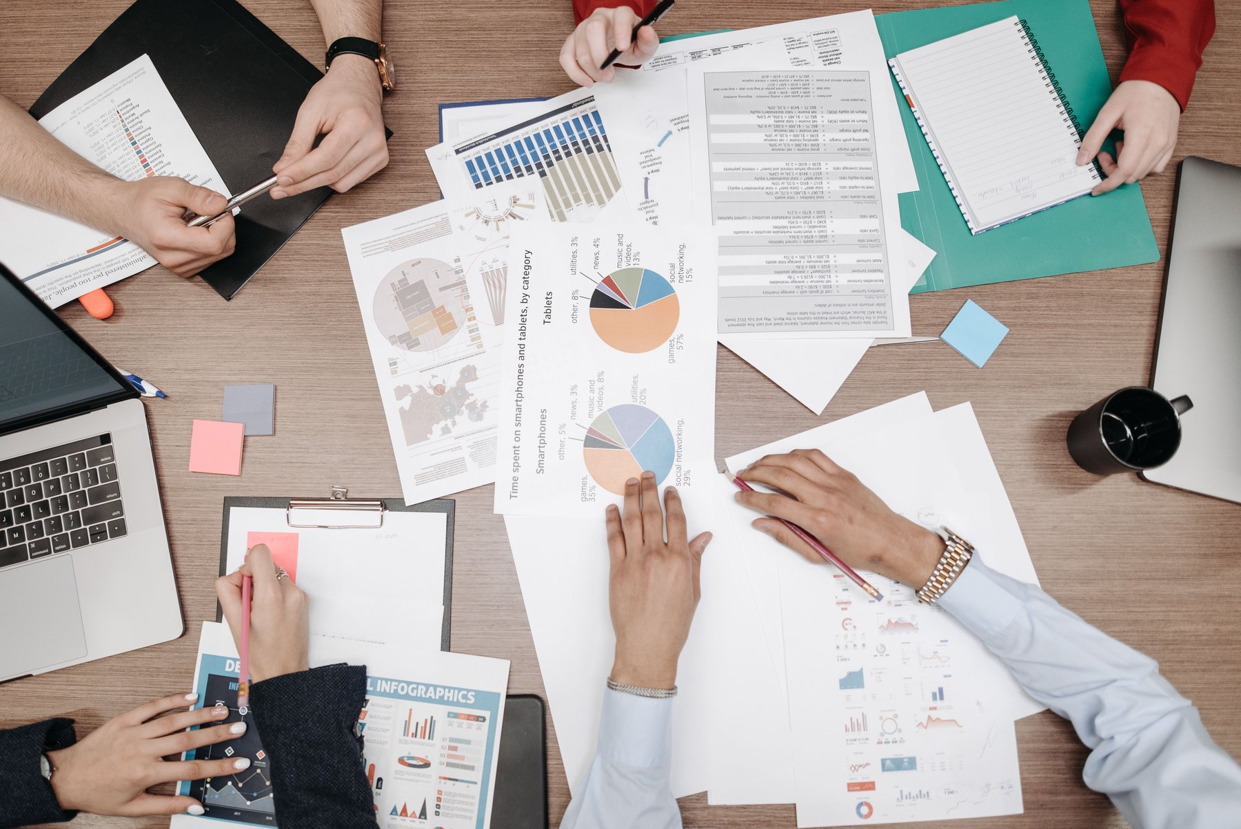 Team reviewing printed charts and reports around a desk